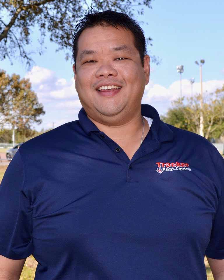 William Chow stands at a park