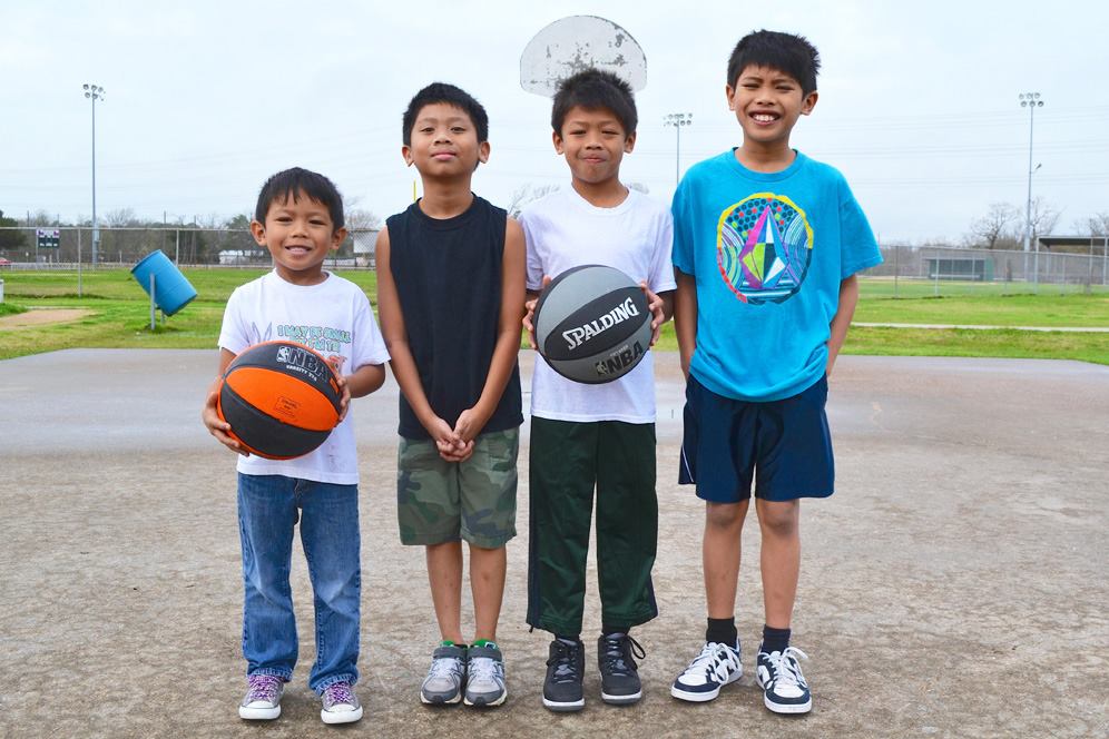 Four boys playing basketball