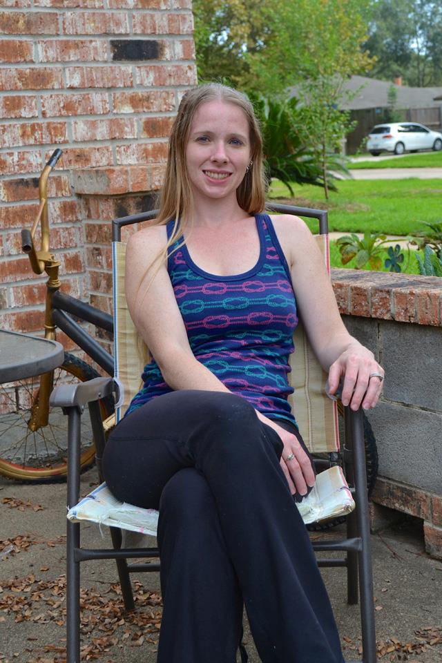 Woman sits outside her home