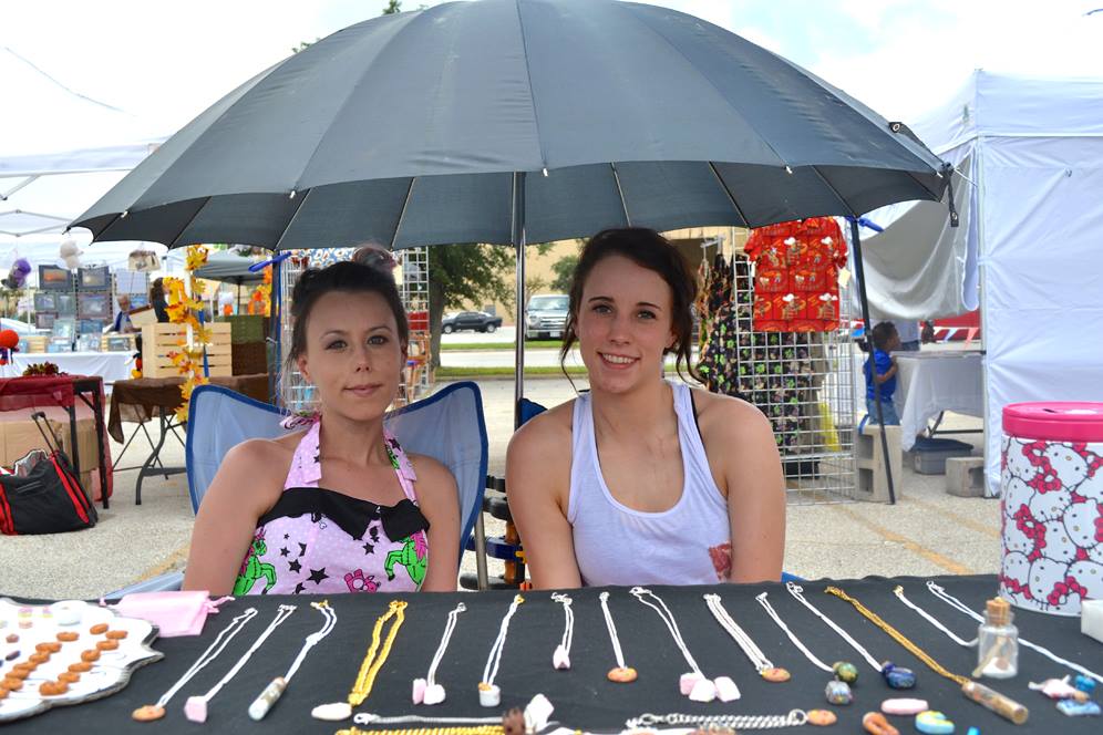 Two young women sitting at table with miniature items