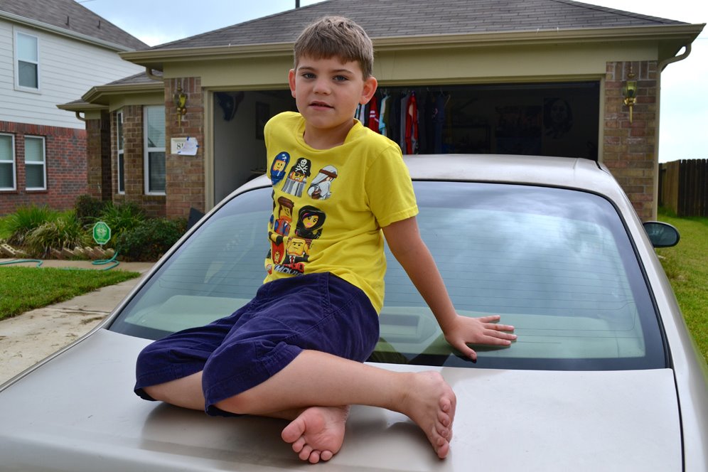 Boy sits on car