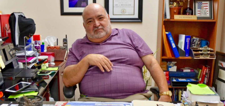 Joe Montemayor sits at his desk