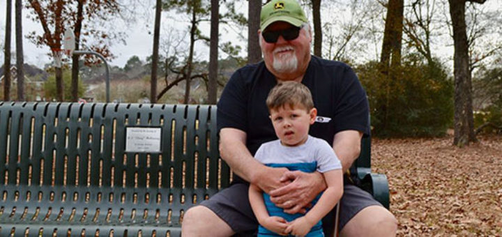 Steve Brown sits on a park bench with his grandson