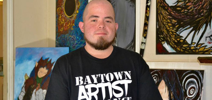 Adrian Sanchez with his paintings