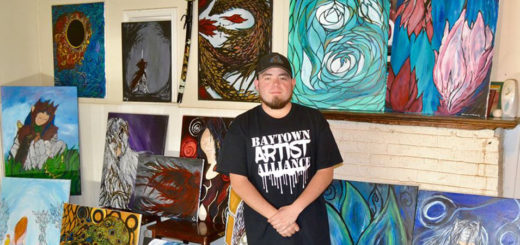 Adrian Sanchez with his paintings