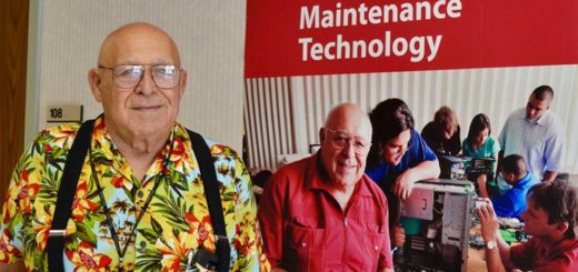 Chuck Ganze stands next to poster at Lee College
