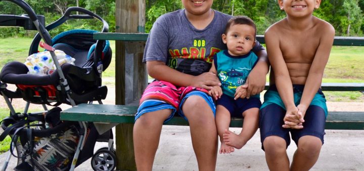 Three of Melly Rendon's sons sit at a picnic table