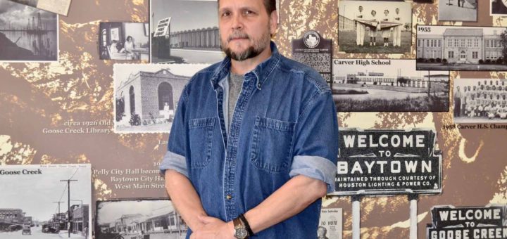 Russell Hamman stands in front of historic Baytown photos