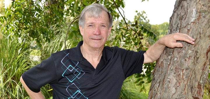 Tom Shelby standing next to a tree