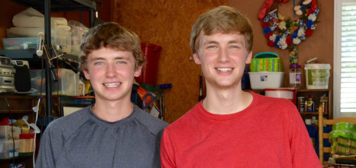 Ethan and Connor Pope sit in the garage