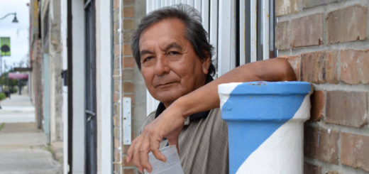 Johnny Reyes stands outside a barber shop
