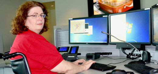 Nancy Worley in a wheelchair at her computer desk