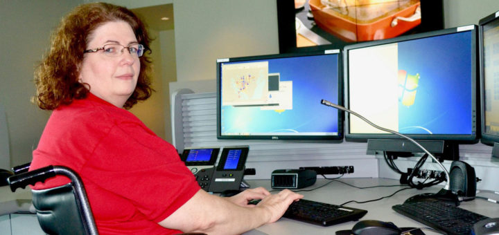 Nancy Worley in a wheelchair at her computer desk