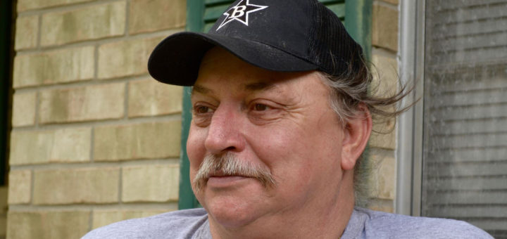 Philip Kysar sits in front of his house