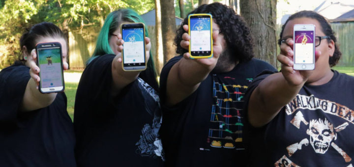 Four girls playing Pokemon Go hold up their cell phones