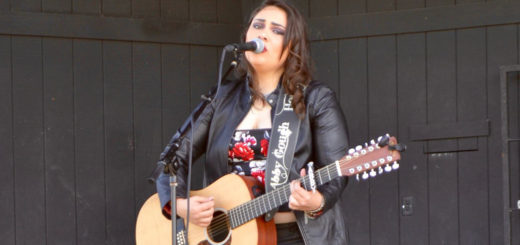 Abby Gough plays guitar and sings on stage