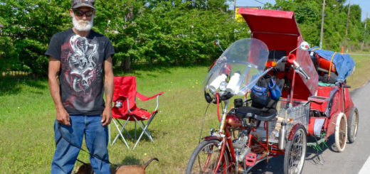 Bike rider with his two dogs at side of road