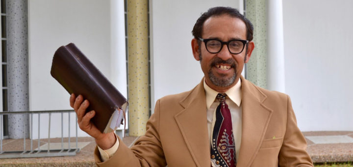 Bohonerges Rodriguez holds a bible outside of library