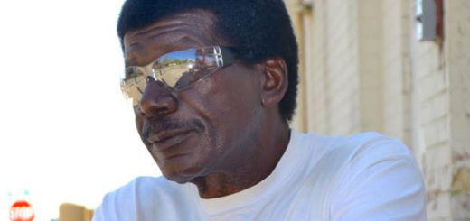 Man sits next to building