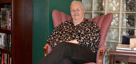 Frankie Johnson smiles while sitting in chair