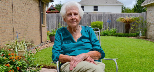 Woman sits in a chair in her yard