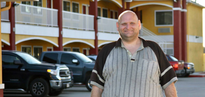 Joshua Johnson stands in motel parking lot