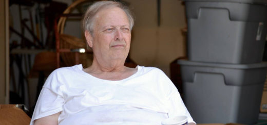 Roy Christina sits in front of his garage