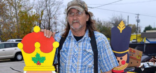 Man stands next to woodworking project