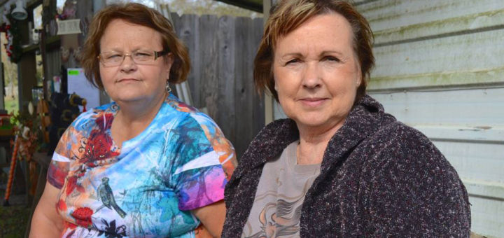 Two women sit together outside