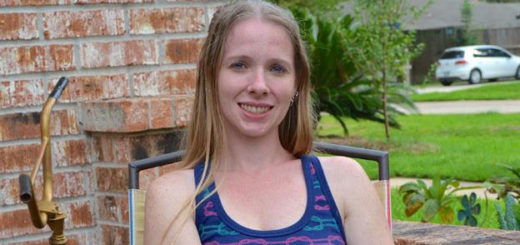 Woman sits outside her home