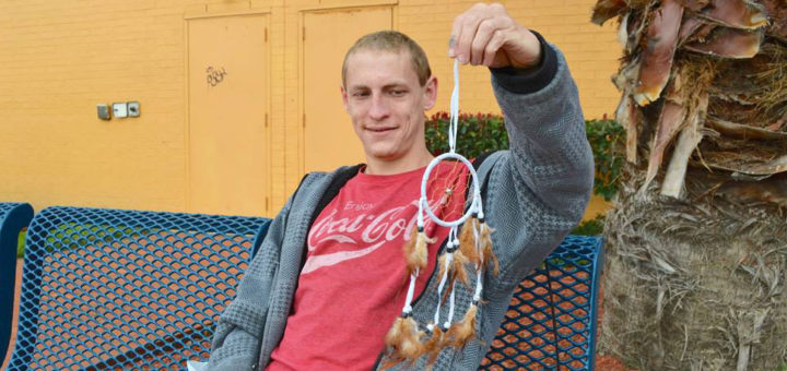 Young man holds a dreamcatcher