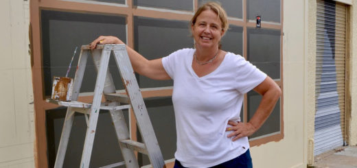 Suzanne Sellers stands hear mural