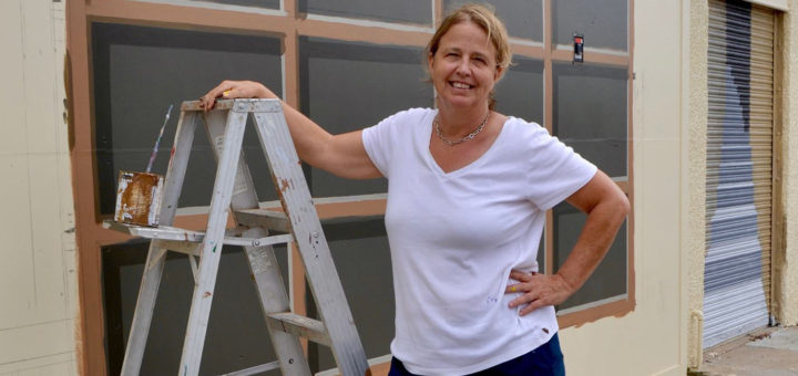 Suzanne Sellers stands hear mural
