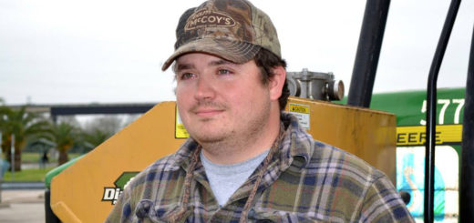 Tractor driver stands near his machine
