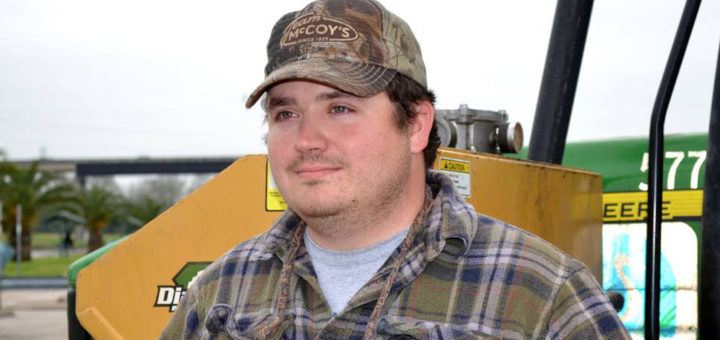 Tractor driver stands near his machine