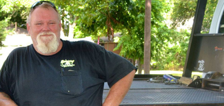 Wrecker driver stands near truck