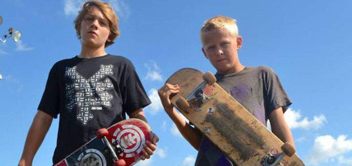 Two boys holding skateboards