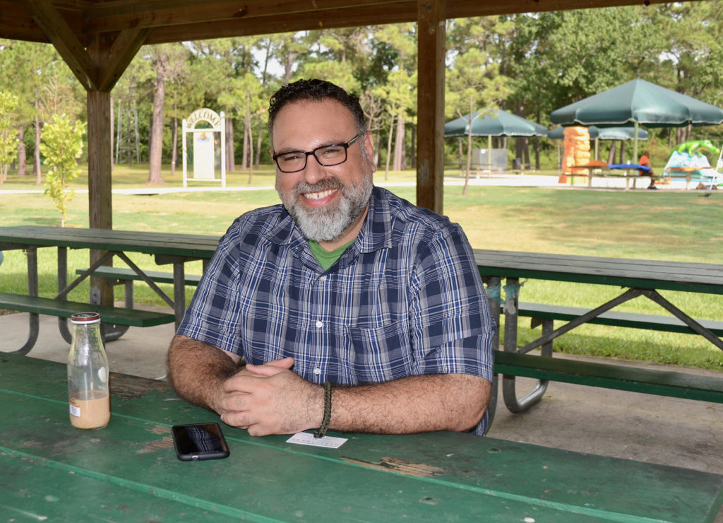 Jesse Garcia sits at a picnic table