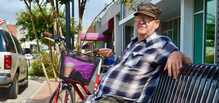 John Bounds sits on bench near his bike