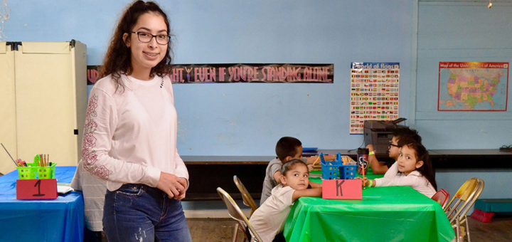 Evelyn Torres stands near young students
