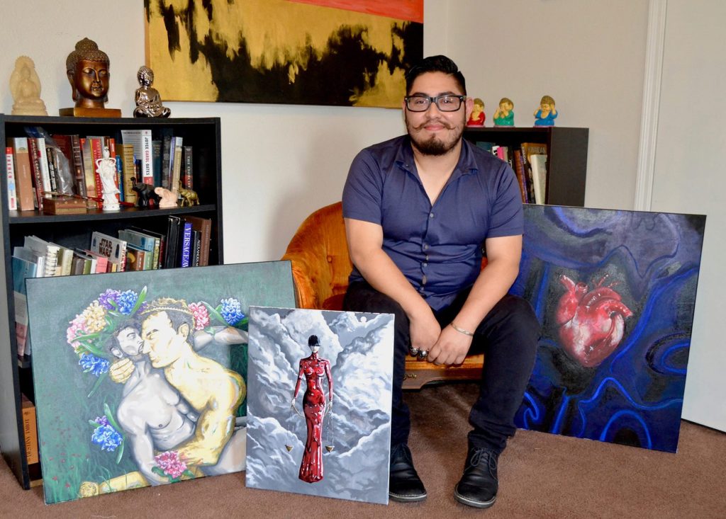 Joshua Villegas with some of his paintings