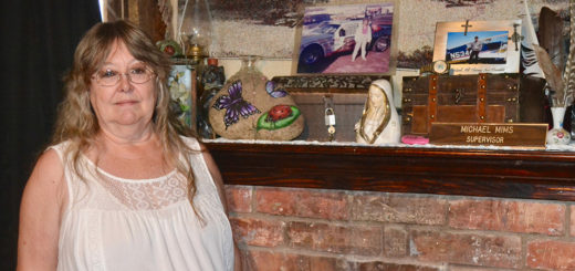 Marian Mims stands next to the cremated remains of her husband and daughter