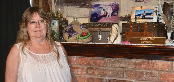 Marian Mims stands next to the cremated remains of her husband and daughter