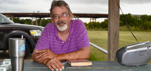 DeWayne Saxton sits at a picnic table