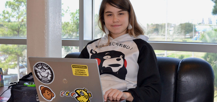 Madilyn Lawrence sits with her laptop computer